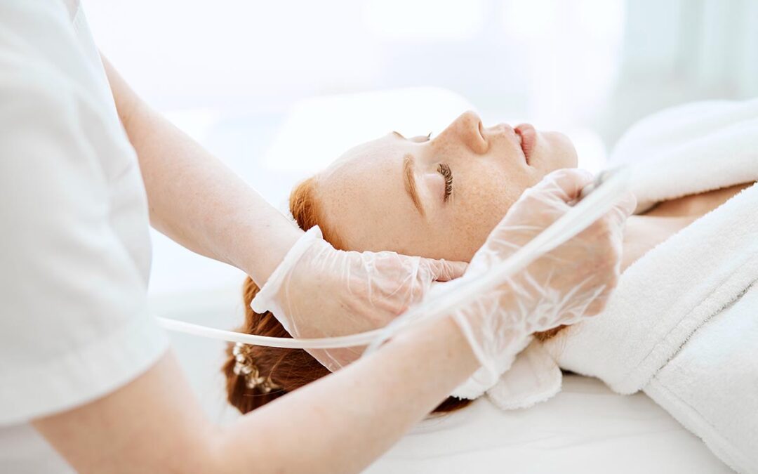 Woman getting face peeling procedure in beauty centre.