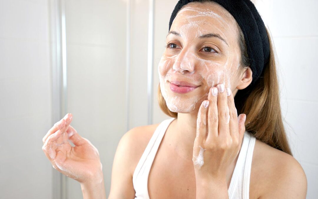 Young Skin Care Routine. Girl washing face foaming soap scrubbin